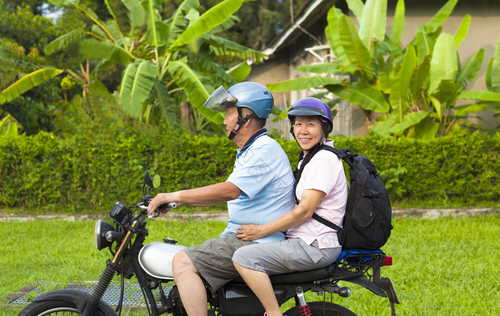 亚洲的年长夫妇驾驶摩托车旅行