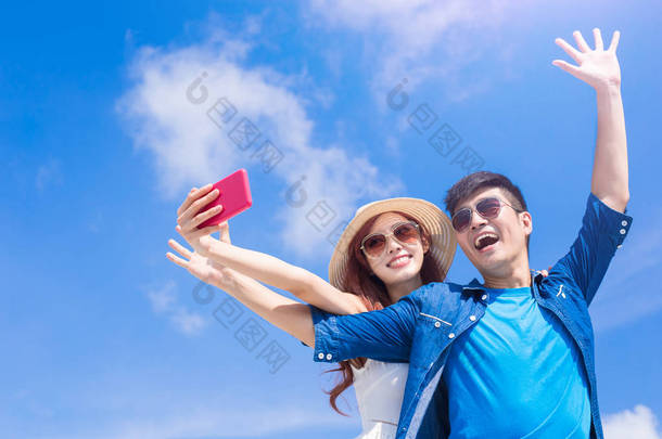快乐与蔚蓝的天空背景上夫妇以自拍照
