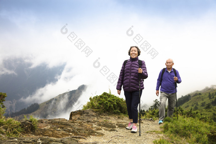 幸福的亚洲高级夫妇在山上徒步旅行