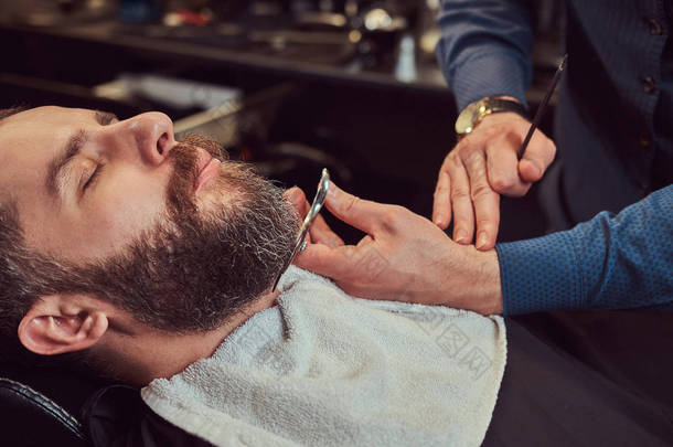 专业理发师建模胡子与剪刀和梳子在理发店。特写<strong>照片</strong>.