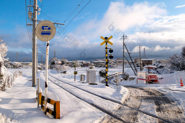 与白色的雪落在寒冬季节，日本当地火车的铁路轨道