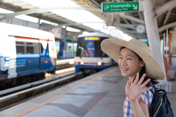亚洲逗人喜爱的女孩在去轻轨车站旅行之前感觉幸福在大城市的旅行, 生活方式和运输概念