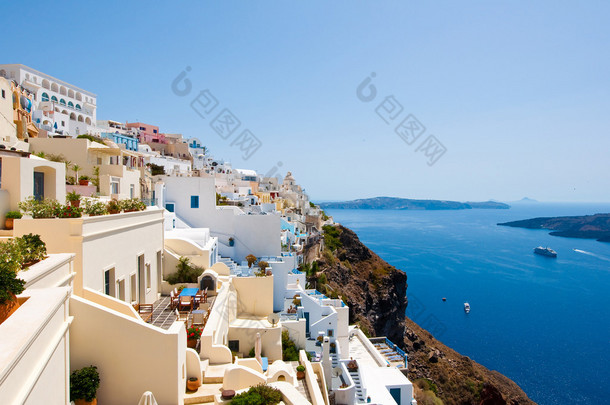 Panorama of Fira with whitewashed buildings carved into the rock on the edge of the caldera cliff on