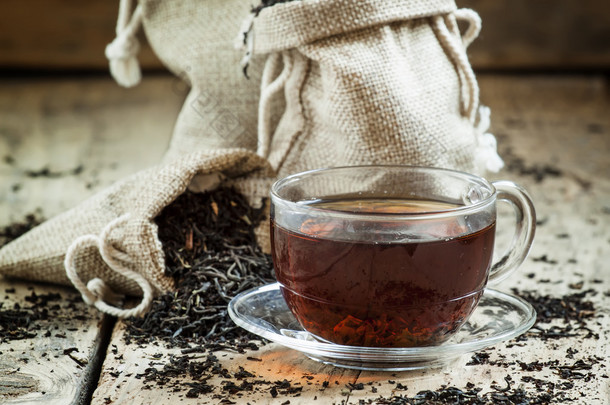 玻璃透明杯红茶和干燥的茶叶袋 