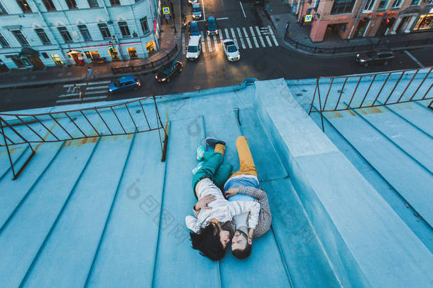 年轻的时髦夫妇躺在屋顶上