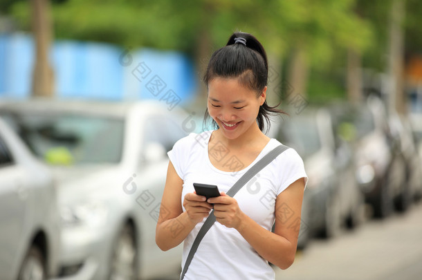 女人用她的手机走在停车场