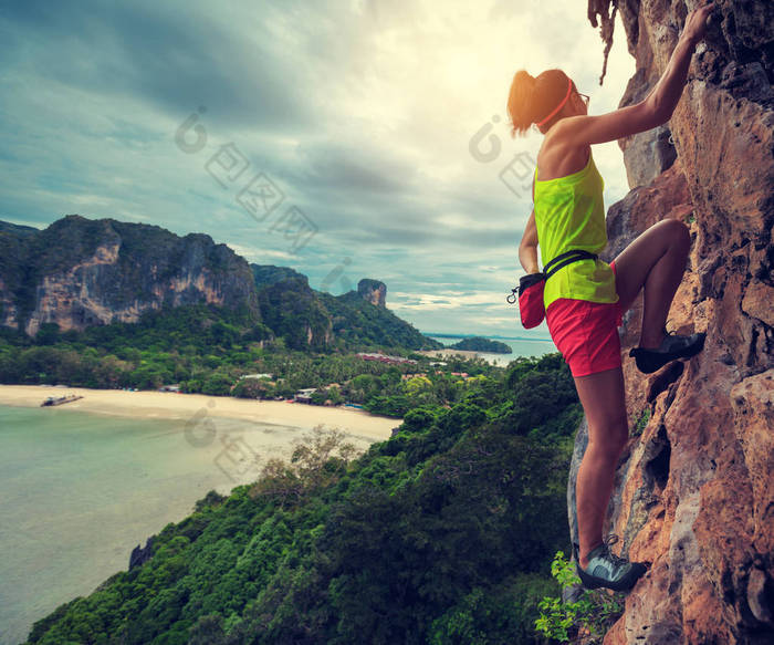 女人在海边悬崖攀登