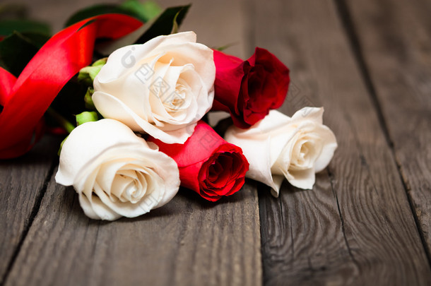 Red and white roses on a dark wooden background. Women' s day, V