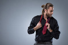 年轻的大胡子男子在黑色的衬衫, 他的脖子上的红色领带, 孤立的灰色  
