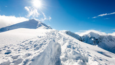 冬天与灿烂的阳光和蓝色的白雪覆盖的山顶