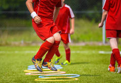 年轻的足球运动员在球场上练习。足球足球设备。动态跳跃式的足球训练