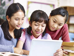 亚洲小学女生在课堂经验休息期间使用平板电脑