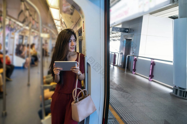亚洲女乘客使用平板电脑 