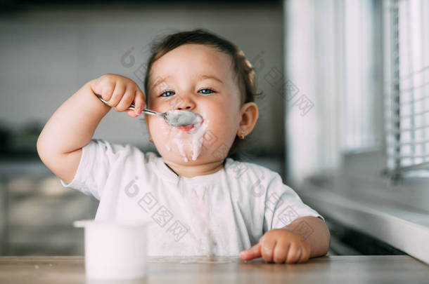 一个迷人的小女孩吃酸奶都<strong>涂抹</strong>自己