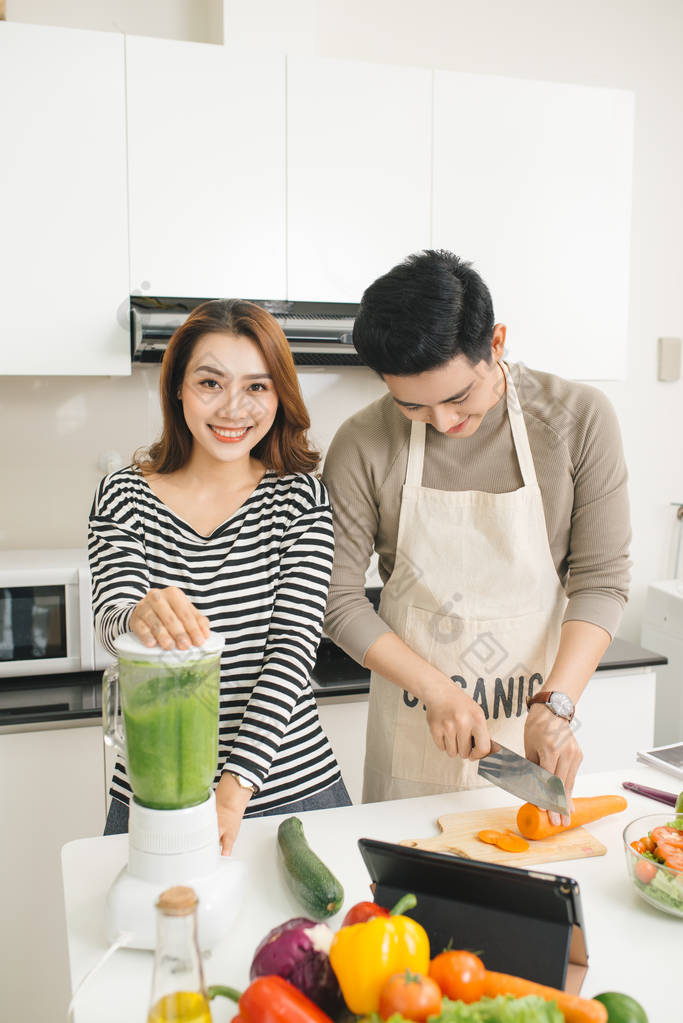 亚洲的夫妻情人在家里的厨房做饭，在一起