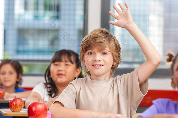小<strong>学生举手</strong>示意，在教室里。教育理念