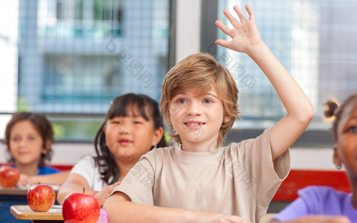 小学生举手示意，在教室里。教育理念