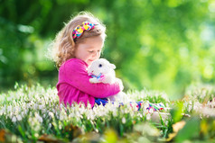 小女孩玩寻找复活节彩蛋的兔子