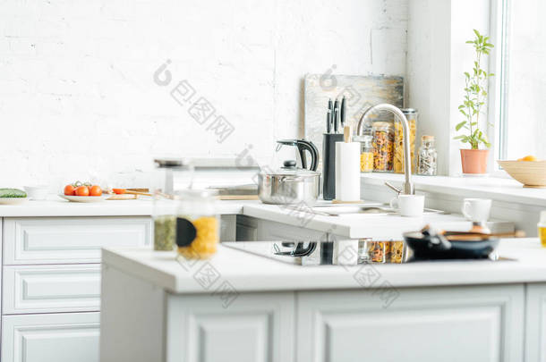空的现代白色厨房的内部与各种各样的对象在桌上