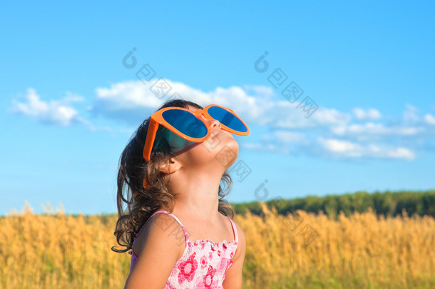 快乐的小女孩，看着天空的大墨镜