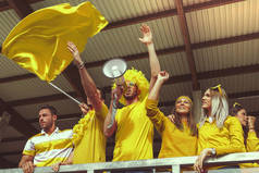 一群身穿黄色衣服的粉丝观看体育赛事