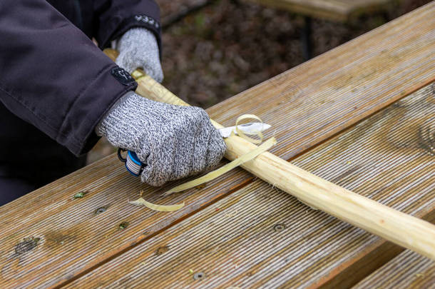 为安全起见，儿童手用小刀在树枝上手工制作，带有防割手套的树枝与锋利的小刀一起制作，是一种危险的室外活动，没有防割手套和衣服