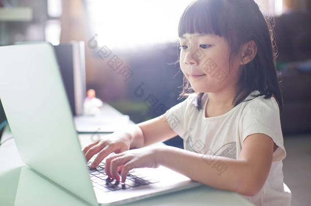 <strong>小小</strong>的亚洲女孩使用的便携式计算机 