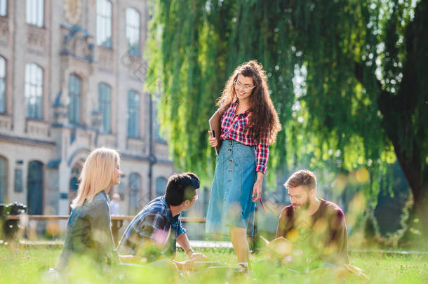 以大学为<strong>背景</strong>的多种族学生在公园里休息