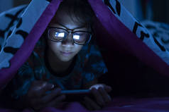 女孩戴着眼镜在卧室的黑床上使用手机