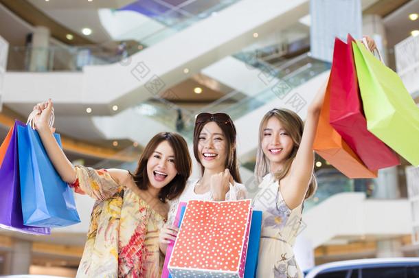 快乐妇女组携带购物袋在购物中心