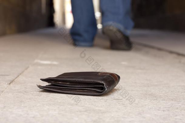 丢失的钱包上的街和步行的人概念的腿