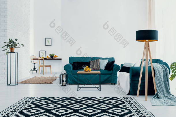 花纹<strong>地毯</strong>和植物在白色公寓内部与灯和大理石绿色<strong>沙发</strong>。真实照片