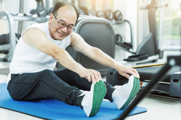 亚洲高级人在健身房锻炼之前的伸展运动。复制 spac
