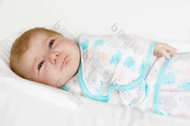 可爱的小刚出生的婴儿的女孩，哭包裹在白色
