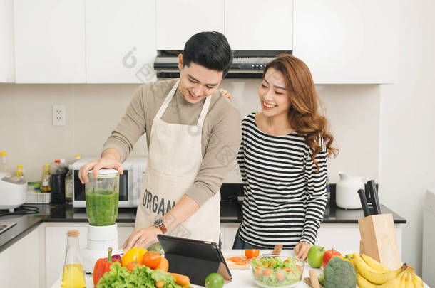 工具包中一起煮饭的快乐亚洲年轻夫妇的肖像
