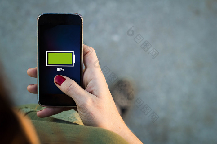 Woman walking with smartphone full battery on screen