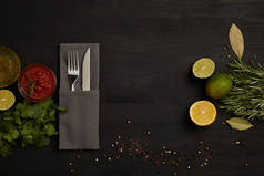 平躺与餐具, 酱油, 迷迭香, 香料和柑橘水果件在黑色桌面上