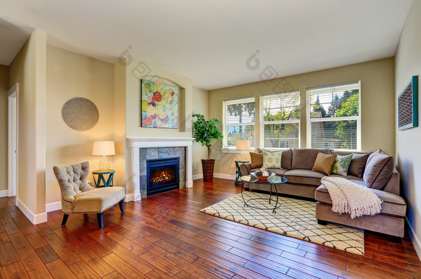 舒适的客厅，带壁炉、米色<strong>墙壁</strong>和硬木地板
