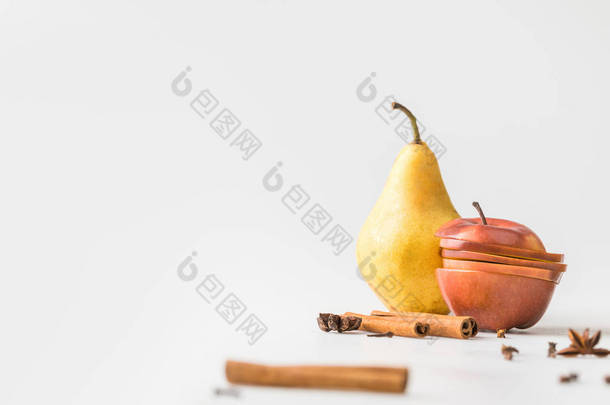 苹果和梨在白色表面上的香料的特写镜头