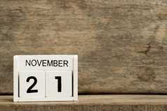 白色方块式日历当前日期21和月11月在木背景