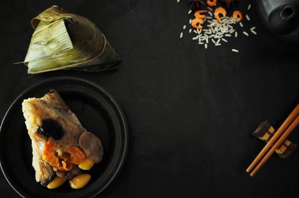 中国菜黑背景上的茶壶粽子