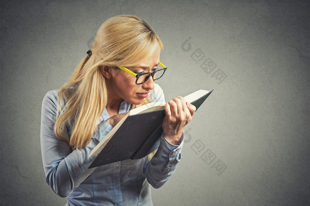 woman with eye glasses trying read book, has bad vision