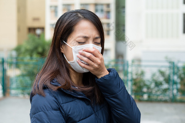 亚洲的年轻女人生病，戴着口罩