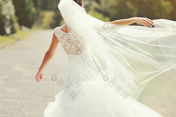 幸福的黑发新娘纺纱周围的面纱