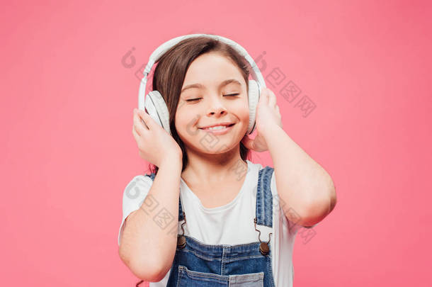 <strong>微笑</strong>的孩子听音乐在耳机查出在粉红色 