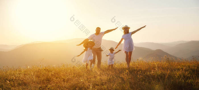 快乐的家庭: 母亲, 父亲, 孩子的儿子和女儿在自然日落