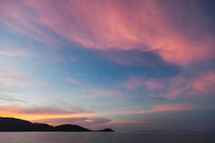 粉红色多云的天空下美丽的日落海景