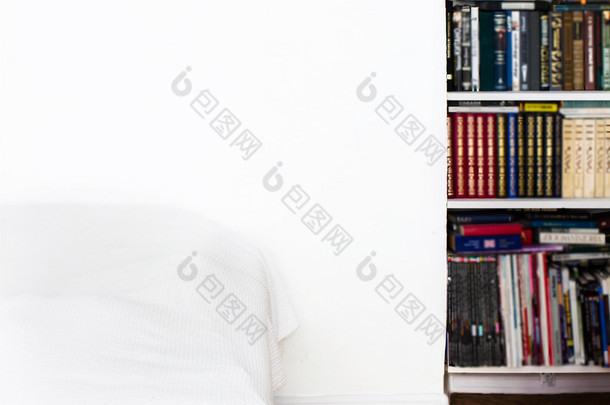 白色的墙壁、 床、 书案例和镶木地板的房间.