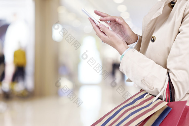 女人在购物时使用手机