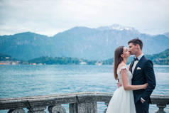 新婚夫妇接吻的背景下的湖泊和山区在晚上